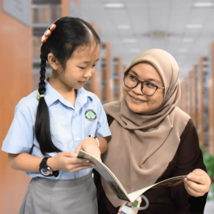 Teacher looking at a book with one of her students