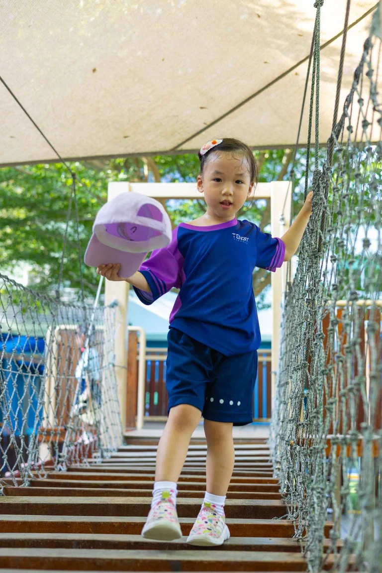 Kindergarten student walking with a baseball hat in her hand