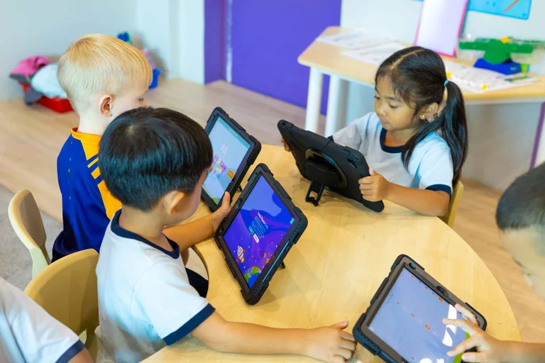 Kids playing with their tablets on a desk