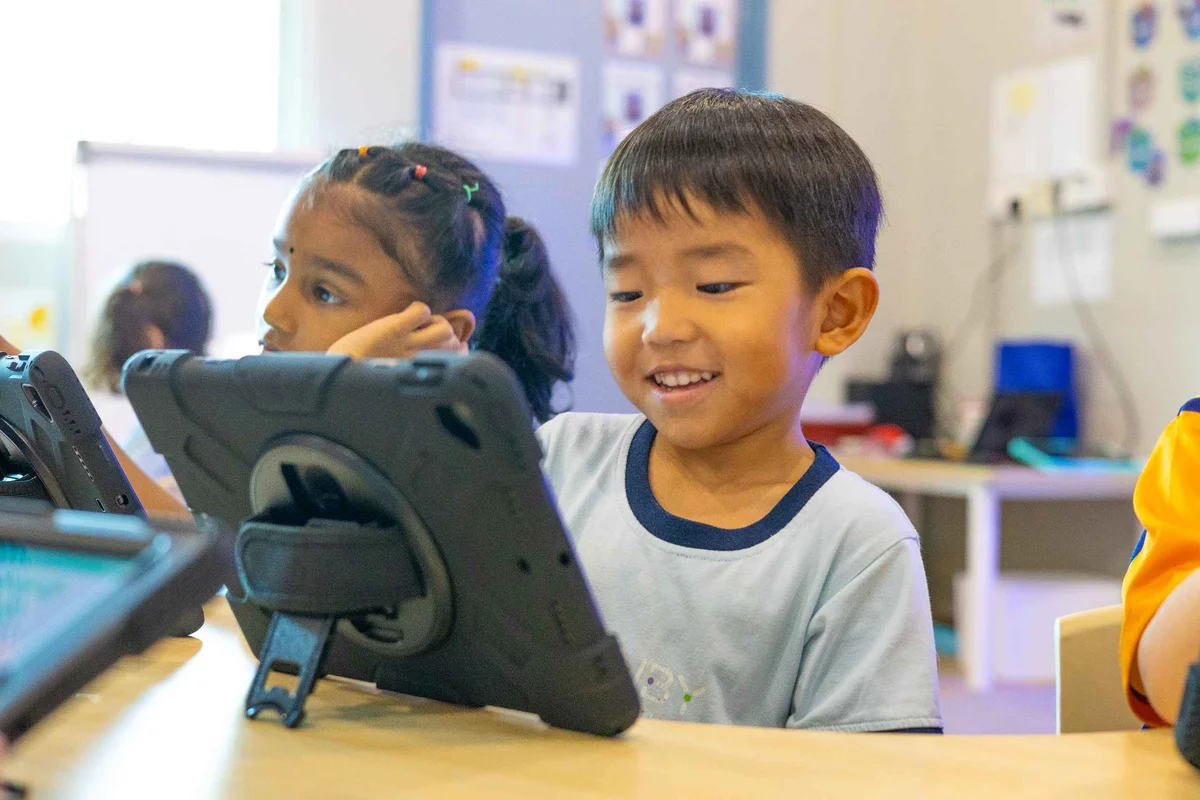 Kid smiling while using a tablet