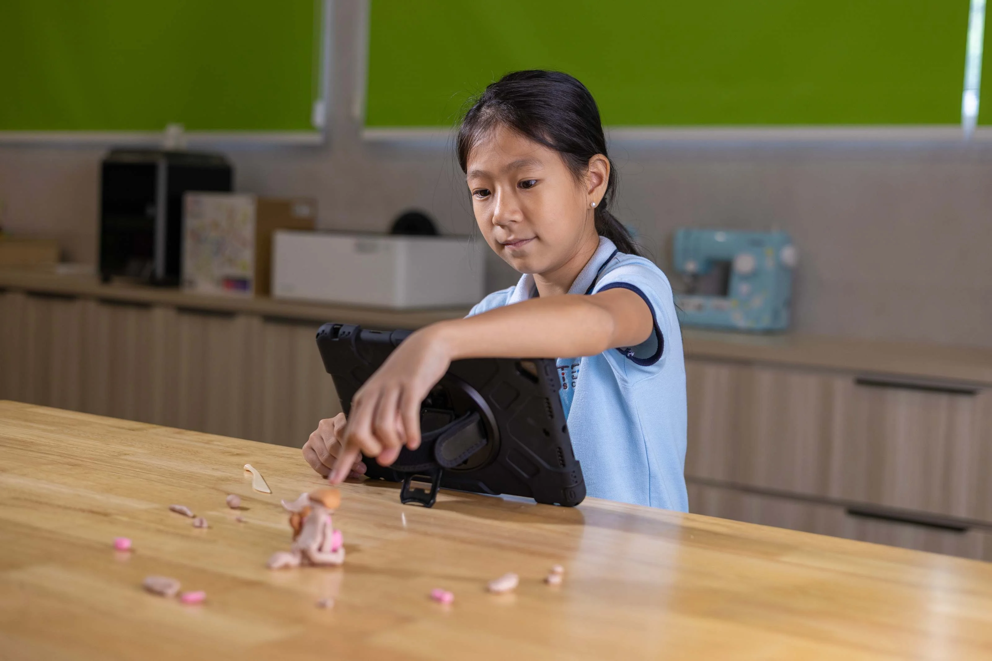 Girl touching something on a table with her index finger