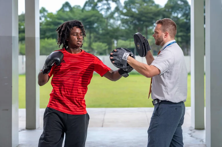 Boy practicing boxing with his teacher