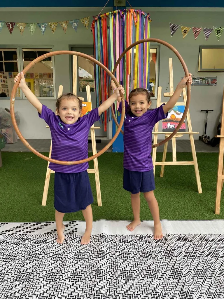 Children smiling while holding wooden circles