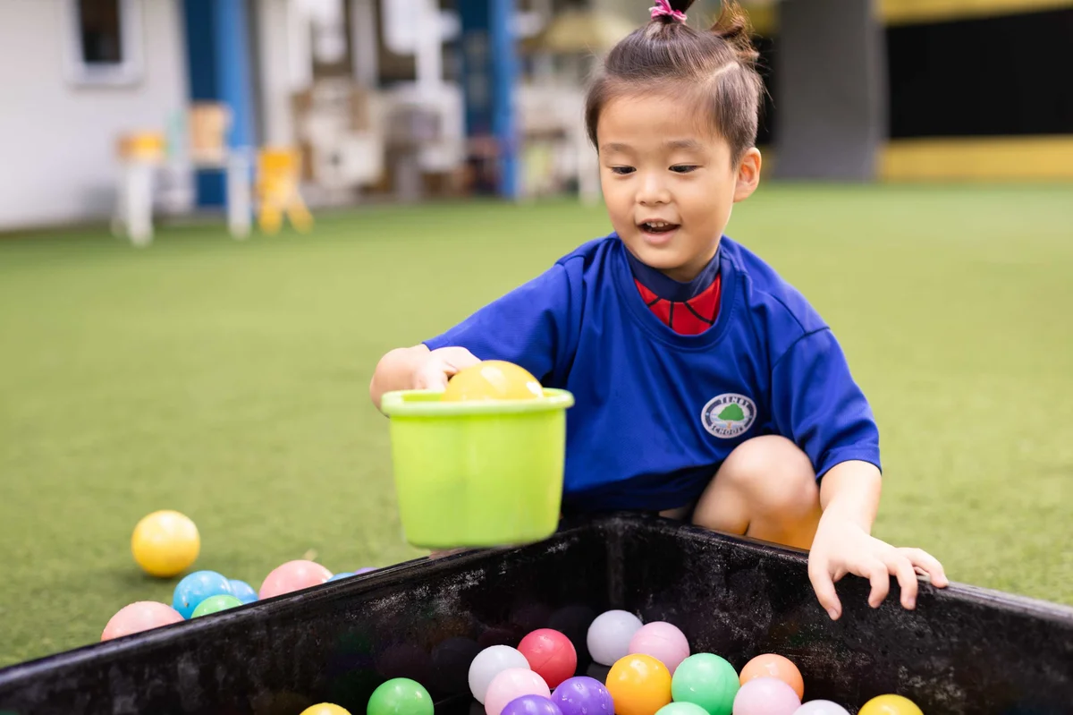 Student taking plastic balls out of a ball pit
