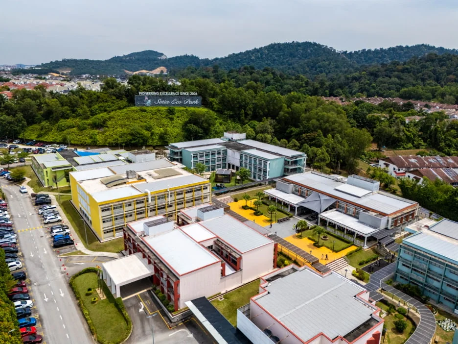 Aerial view of Setia Eco Park with colorful buildings, lush greenery, and parked cars, showcasing modern architecture and nature.