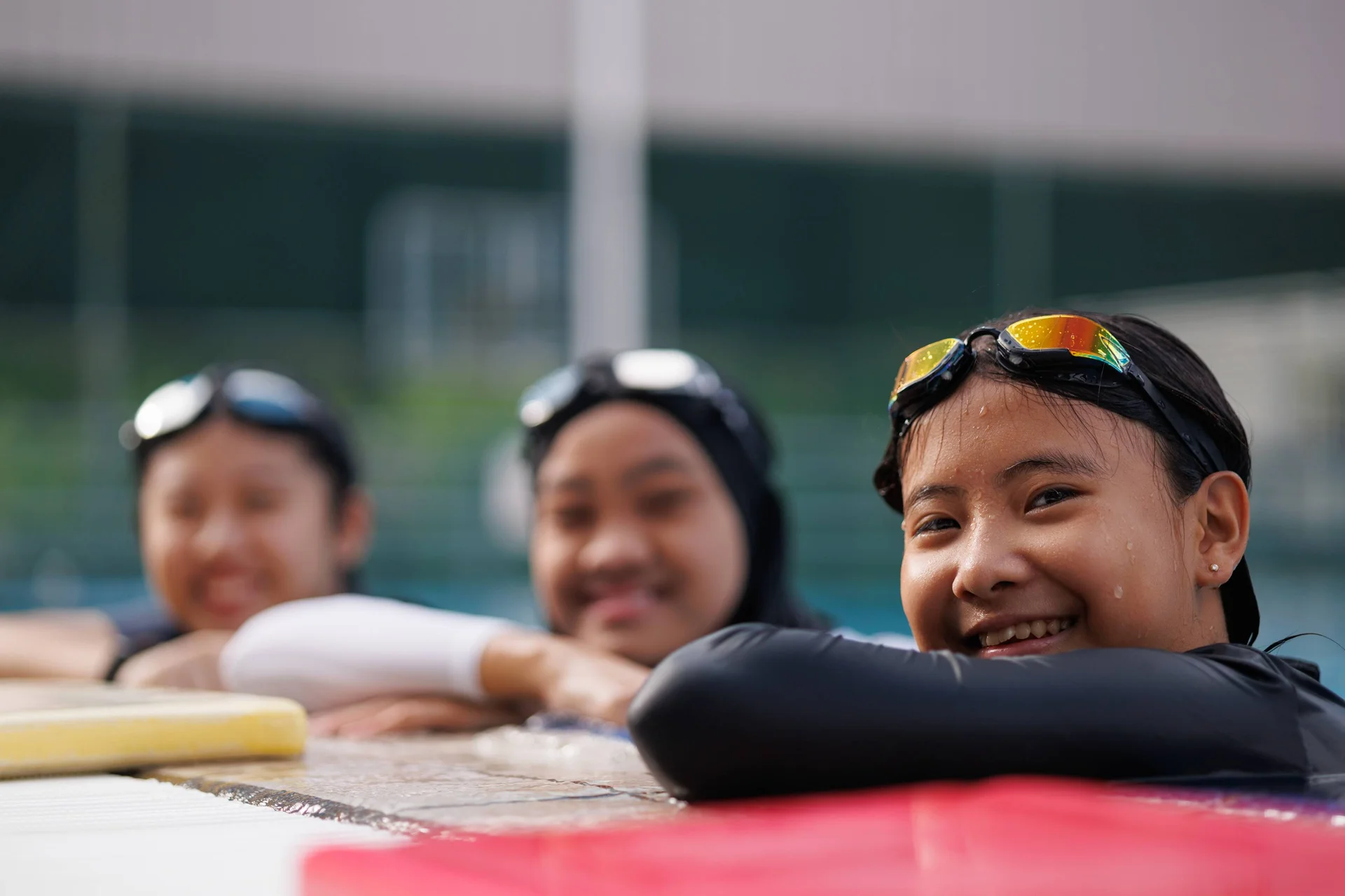 Teenagers smiling while looking at a laptop screen